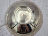a silver bowl sitting on top of a marble table