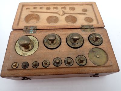 une petite boîte en bois ornée de boutons, posée sur une surface blanche