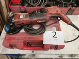une perceuse rouge posée sur une table avec d'autres outils