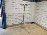 an image of a tripod stands in front of a wall with a sign