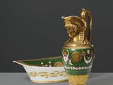 un vase vert et doré posé à côté d'un bateau blanc