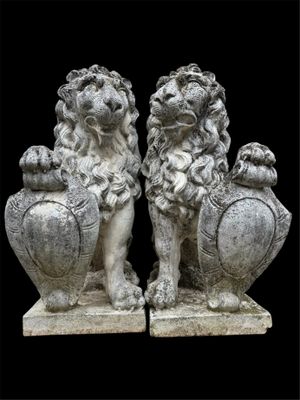 paire de lions en pierre avec une urne et des vases sur fond noir
