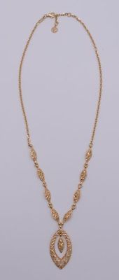 un collier en or muni d'un pendentif circulaire suspendu à une chaîne