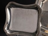 paire de plateaux argentés sur des supports, sur fond noir