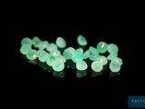 a close up of a bunch of green gems on a black surface