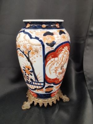 a vase that is sitting on a stand on a black background
