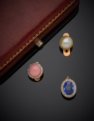 deux paires de boucles d'oreilles et une bague posées sur un fond noir