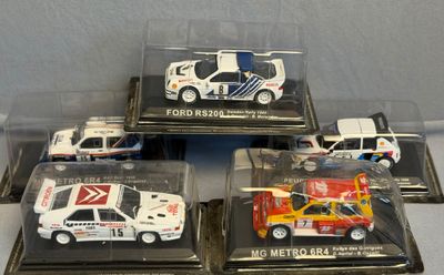 quatre modèles réduits de voitures dans une vitrine posée sur une table