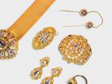 a lot of gold jewelry on a white surface