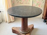 une petite table avec un plateau en marbre dans une pièce