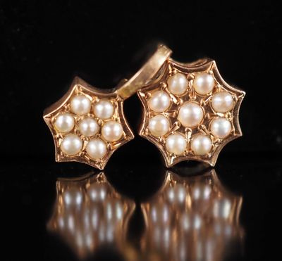 two pairs of gold and pearl earrings on a black surface