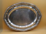 a silver plate that is sitting on a shelf