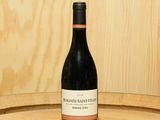 une bouteille de vin posée sur un tonneau