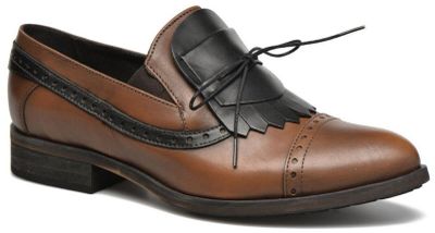 les chaussures marron et noires sont posées sur une surface blanche