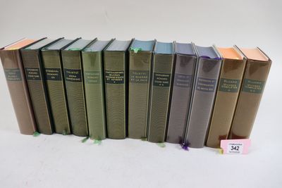 plusieurs livres sont alignés sur une surface blanche