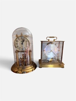 deux horloges placées l'une à côté de l'autre sur une surface blanche