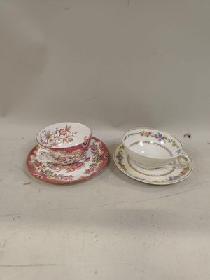 deux tasses et soucoupes sont posées côte à côte sur une table