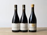 trois bouteilles de vin posées sur une table en bois