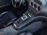 the interior of a black sports car with a steering wheel and dashboard