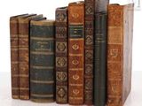 plusieurs vieux livres sont alignés sur une surface blanche