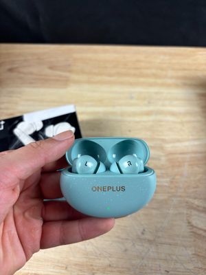 une personne tenant dans sa main une paire d'AirPods OnePlus bleus