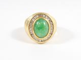 a close up of a ring with a green stone and diamonds