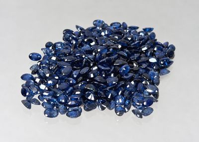 a pile of blue sapphires on a white surface