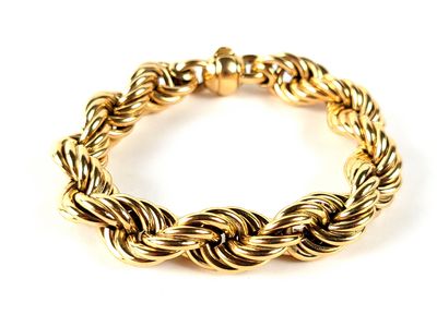gros plan d'un bracelet en or sur fond blanc