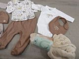 many baby items laid out on a bed together
