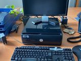 un ordinateur de bureau posé sur une table à côté d'un clavier et d'une souris