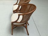 three wicker chairs in a store with a glass case in the background