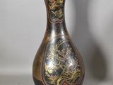 un vase noir et doré orné d'un dragon