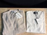 La chemise est blanche et comporte une étiquette.