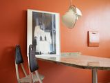 une table et des chaises dans une pièce où est accrochée une horloge au mur