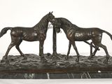 statue of two horses standing next to each other on a marble base