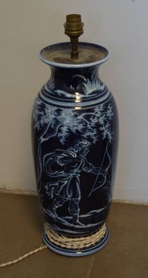un vase bleu entouré d'une corde, posé par terre