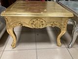 a gold table that is sitting on a tile floor