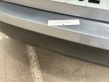 a sticker on the back of a car that is parked in a parking lot