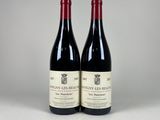 deux bouteilles de vin rouge posées l'une à côté de l'autre sur une table
