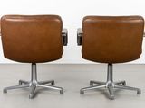 two brown leather office chairs with chrome legs and casteors