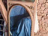 un tableau accroché au mur au-dessus d'un miroir dans une pièce