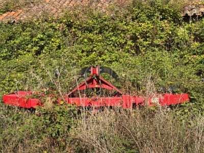 a red tractor that is sitting in the grass