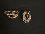 deux boucles d'oreilles en or et diamants posées sur une surface noire