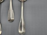 three silver spoons and a fork on a gray surface