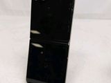 the back of a black cell phone sitting on top of a white table