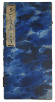 un vieux livre à la couverture bleue posé sur une surface blanche