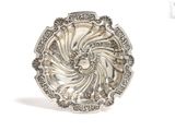 a close up of a silver plate on a white surface