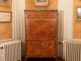 an image of a corner of a room with a cabinet and radiator