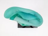 a glass sculpture of a wave on top of a stand