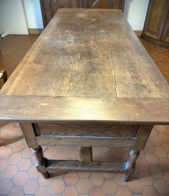 une table en bois avec un plateau en bois posée sur un sol carrelé
